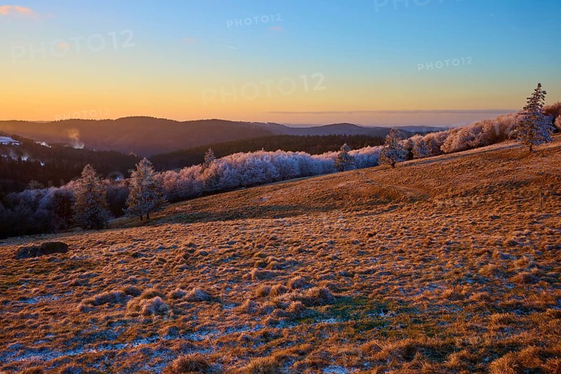 Frosty hills under a bright orange evening sky, winter, Route de Cretes, Hohneck, La Bresse, Vosges, France