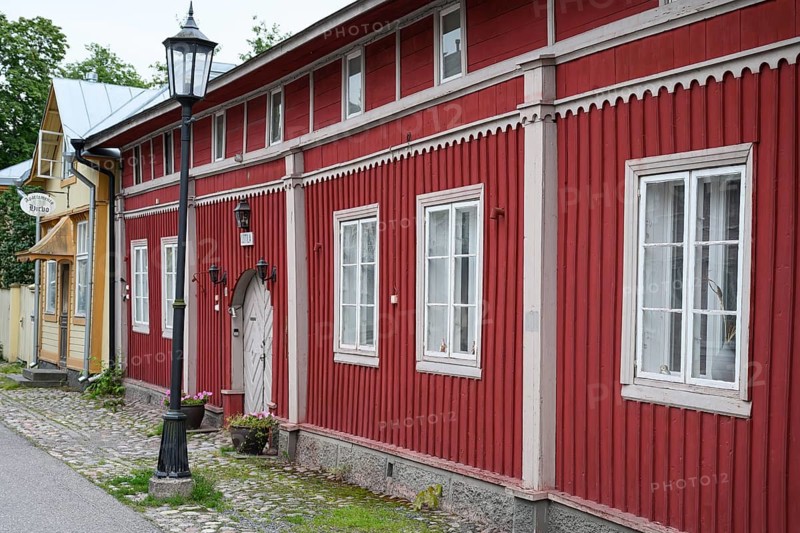 Street scene in the old town of Naantali, red historic wooden building with decorative windows on a paved street, Naanatali, Varsinais-Suomi, Finland
