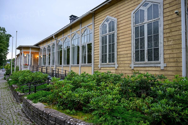 Street scene in the old town of Naantali, yellow building with tall, narrow windows and shrubs planted in front of it conveys peace, Naanatali, Varsinais-Suomi, Finland