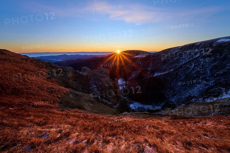 Sunbeams break over the mountains, orange sky and shades of blue, looking towards the Rhine Valley, Martinswand, Frankental, Vosges, France