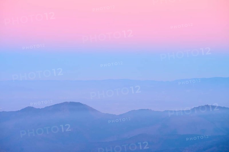 Pale hills in evening fog under a pink sky, looking towards the Rhine Valley, Hohneck, La Bresse, Vosges, France