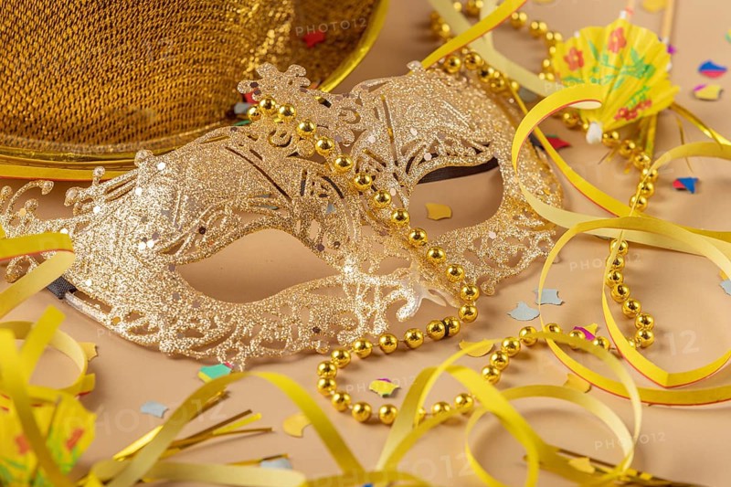 Golden mask with pearls surrounded by carnival decoration