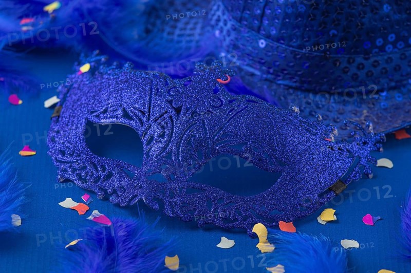 Blue mask with feathers, confetti and hat on blue background, carnival