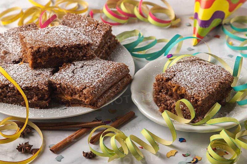 Spice cake with powdered sugar surrounded by colorful streamers and confetti