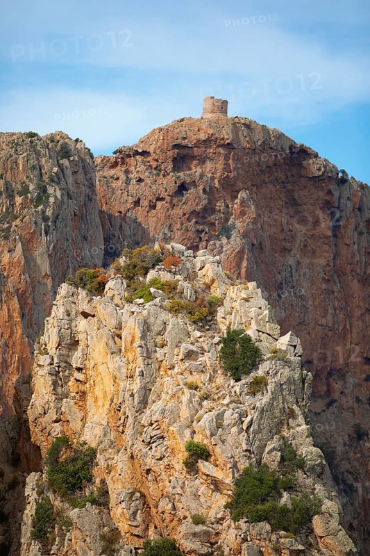 Bizarre rock formations on Capo Rosso, a Genoese tower blurred in the back, Piana, Corse-du-Sud department, west coast, Corsica, Mediterranean, France