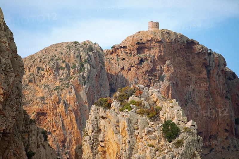 Bizarre rock formations on Capo Rosso, a Genoese tower blurred in the back, Piana, Corse-du-Sud department, west coast, Corsica, Mediterranean, France
