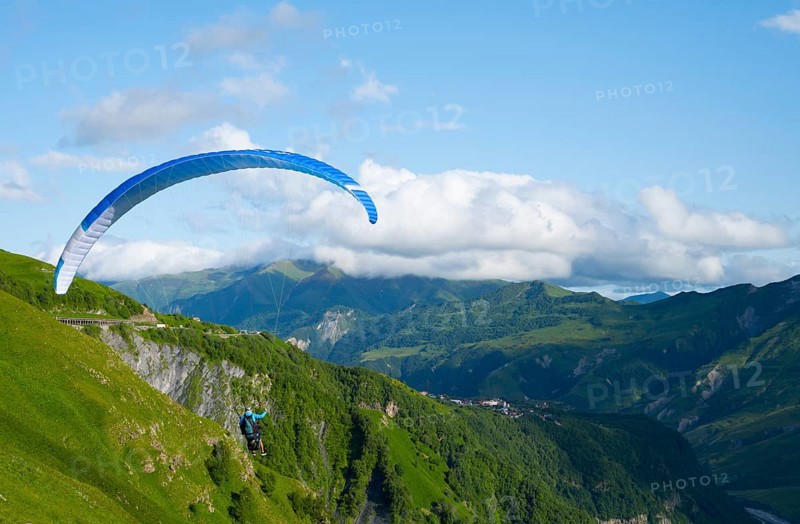 Paraglider flying with blue sky and mountain scenery, a sense of freedom and adventure, paraglider, paraglider near Gudauri, Mtskheta-Mtianeti region, Georgian Military Highway, High Caucasus, Georgia