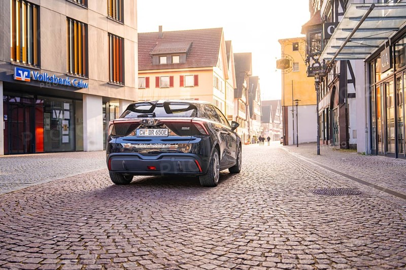 Car parked in a quiet old town with cobblestones and old buildings in diffuse light, MG4 electric car, Deer e-Carsharing, Calw, Germany