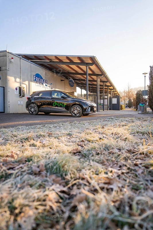 Parked electric car in front of a building on frosty ground on a clear winter morning, MG4 electric car, Deer e-Carsharing, Calw, Germany