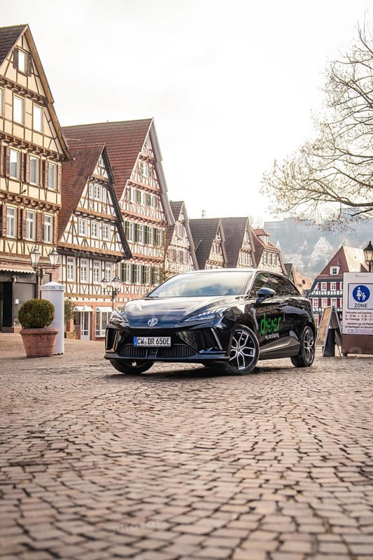 Car parked in a picturesque old town with half-timbered houses and paved streets, MG4 electric car, Deer e-Carsharing, Calw, Germany