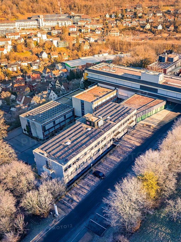 Aerial view of a large building complex surrounded by trees in an autumn landscape, MG4 electric car, Deer e-Carsharing, Calw, Germany