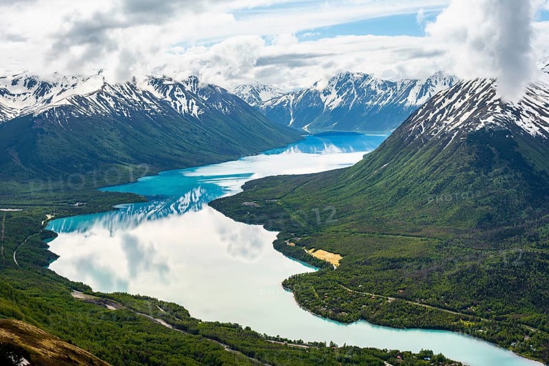 View of snowy mountains in spring and turquoise Kenai Lake with reflection, Slaughter Ridge Trail, Cooper Landing, Kenai Peninsula, Alaska, USA