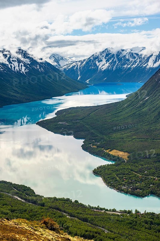 View of snowy mountains in spring and turquoise Kenai Lake with reflection, Slaughter Ridge Trail, Cooper Landing, Kenai Peninsula, Alaska, USA