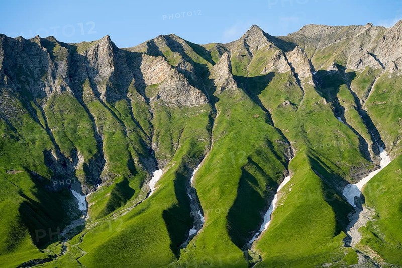 Distinctive rocky ridges with green vegetation under clear, blue air, mountain landscape between Gudauri and the Cross Pass, Mtskheta-Mtianeti region, Georgian Military Route, High Caucasus, Georgia
