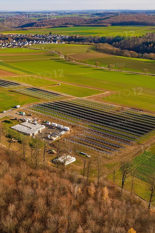 Solar system and building nestled in a green landscape with village surroundings in autumn, energy revolution, construction of PV open space, Baden-Württemberg, Germany
