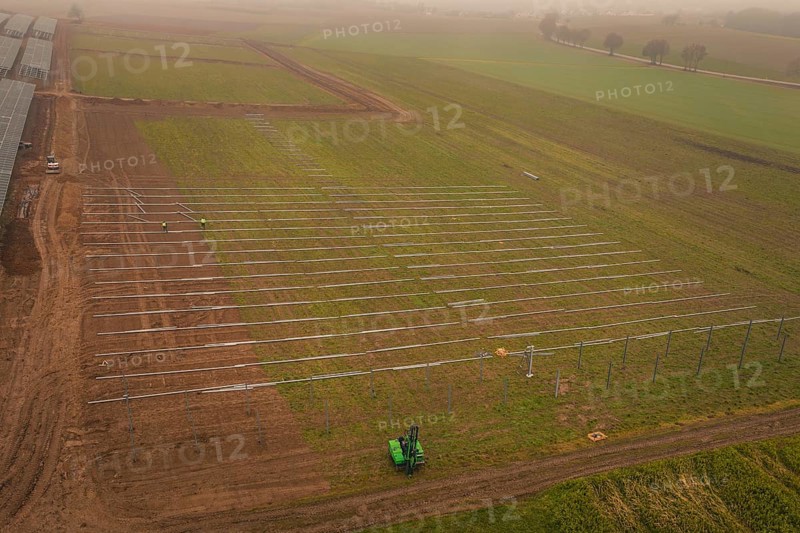 Foggy fields with solar system installation in the foreground, machines in use, energy revolution, construction of PV open space, Baden-Württemberg, Germany