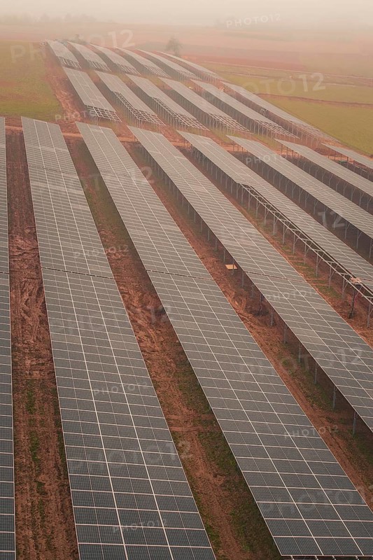 Row of solar panels in a foggy landscape, sustainable energy generation in wide fields, energy revolution, construction of PV open space, Baden-Württemberg, Germany