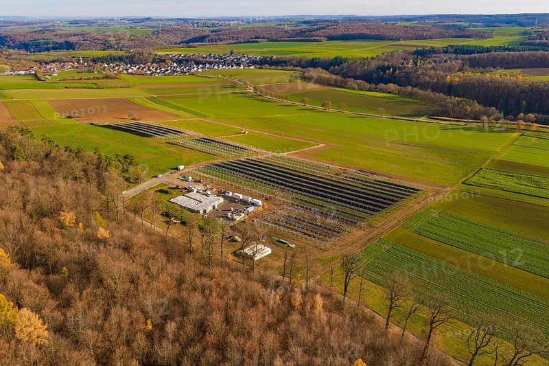 Panorama of a landscape with solar plant, forests and village in an autumn environment, energy revolution, construction of PV open space, Baden-Württemberg, Germany