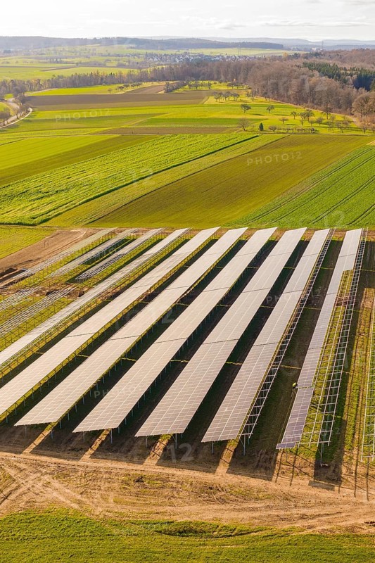 Aerial view of solar panels in an agricultural environment with vast green fields, energy transition, construction of PV open space, Baden-Württemberg, Germany