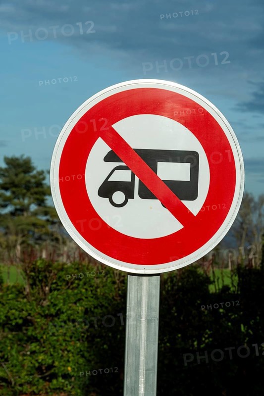 A round prohibition road sign forbids motorhomes. The sign is white with a red border and a red diagonal line through the motorhome symbol in France
