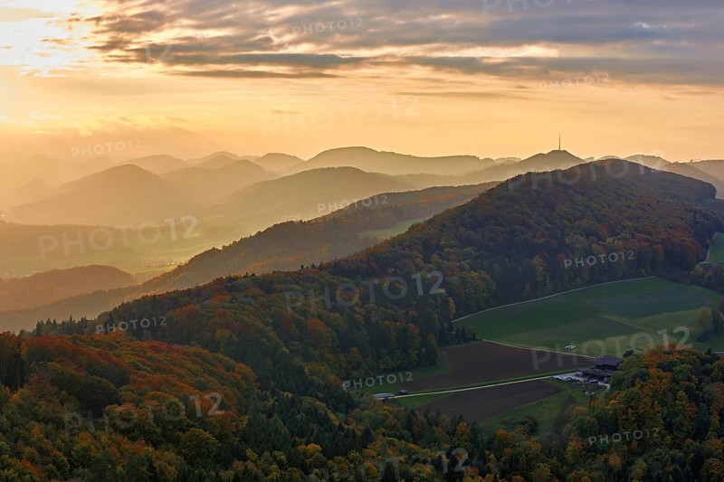 View of an autumnal forest from the Gisliflue, behind the Jurassic foothills with the water fluh in the light of the setting sun, Talheim, Canton, Aargau, Switzerland