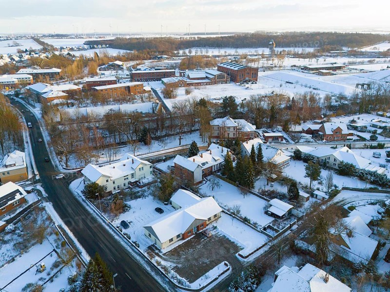 Snowy village with houses, roads and surrounding winter landscape, aerial view, Oelsburg, Ilsede municipality, Peine district, Lower Saxony, Germany