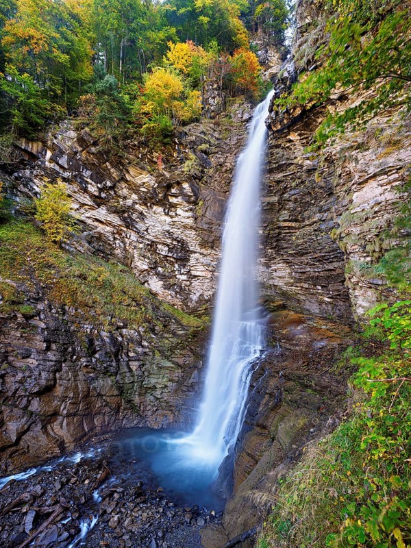 Diesbach waterfall in autumn-colored surroundings, Linthal, Klausenpass, Canton of Glarus, Switzerland