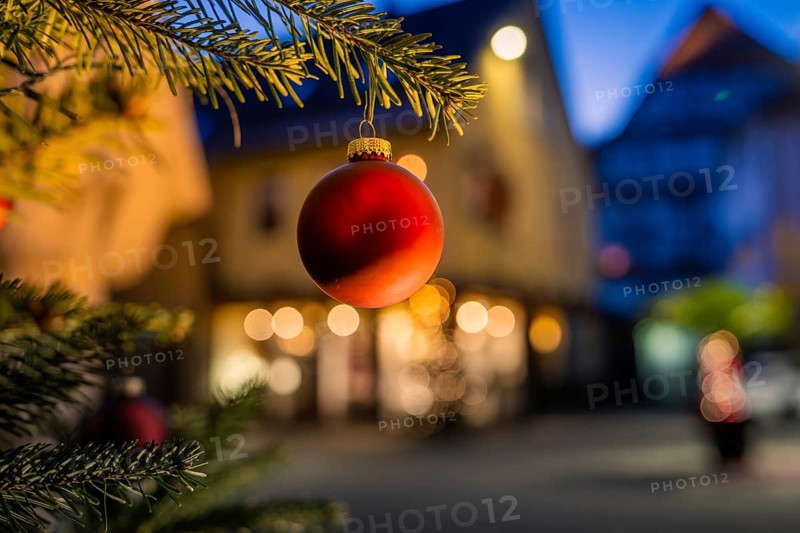 Red Christmas ball hanging on pine branch, blurred illuminated background, Nagold, Calw district, Black Forest, Germany