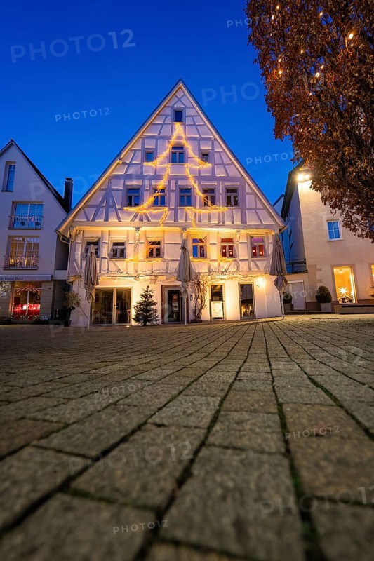 Half-timbered house with Christmas tree-shaped fairy lights against evening sky, Nagold, Calw district, Black Forest, Germany