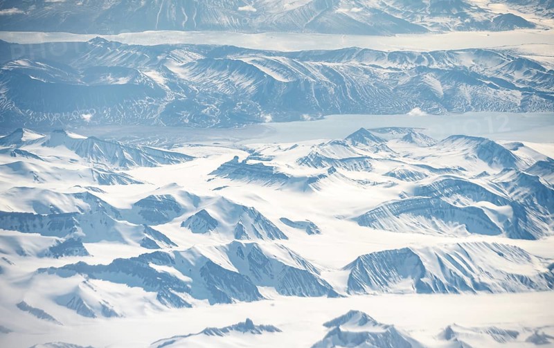 Icy, snowy arctic mountain landscape with glaciers and fjords, aerial view, Greenland, Arctic