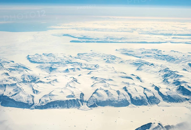 Wide snowy landscape with mountain ranges and huge glaciers, aerial view, Greenland, Arctic