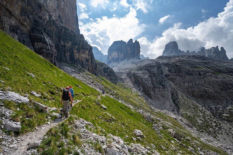 Two mountaineers on a hiking trail in front of a picturesque mountain landscape with rocky peaks, Via Ferrata SOSAT via ferrata, summit of Cima Tosa in the back, Brenta Mountains, Trentino, Italy