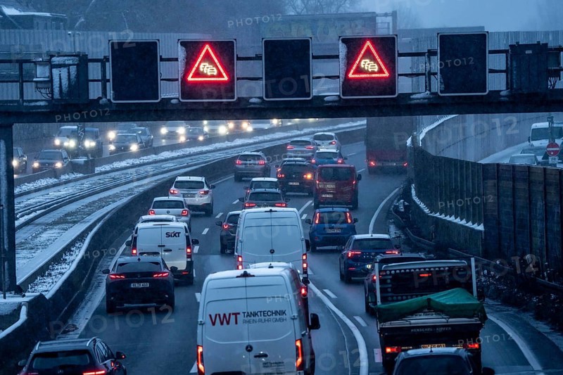 Winter weather, motorway traffic, A40 motorway, Ruhrschnellweg, in Essen, at the Essen-Ost motorway junction, snowfall, traffic jams, heavy flowing traffic, North Rhine-Westphalia, Germany