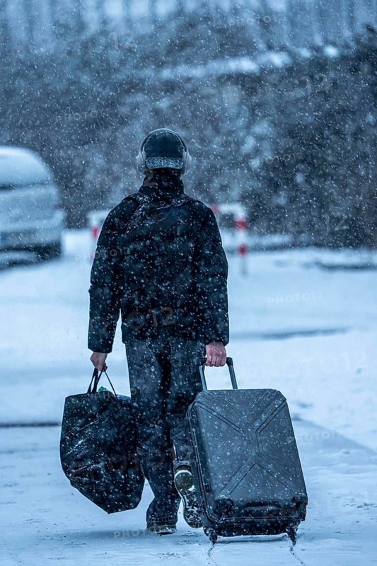 Winter weather, blowing snow, person with luggage on sidewalk, North Rhine-Westphalia, Germany