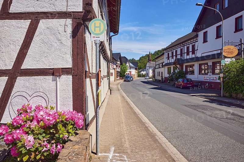 Bus stop Insul Gasthaus Keuler, Landgasthaus Café Keuler, residential buildings and commercial buildings, general architecture, historic half-timbered houses, parking strips with cars, lantern, flower, hill, forest, blue sky, cirrus clouds, cirrostratus clouds, main street, Insul, district of Ahrweiler, Rhineland-Palatinate, Germany