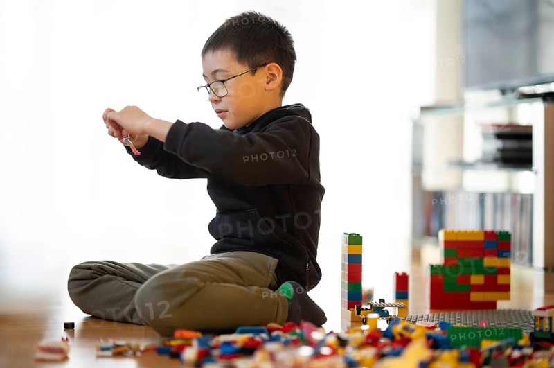 Boy, 6 years, glasses, multi-ethnic, plays with Lego, concentrates, constructs, builds, Stuttgart, Baden-Württemberg, Germany