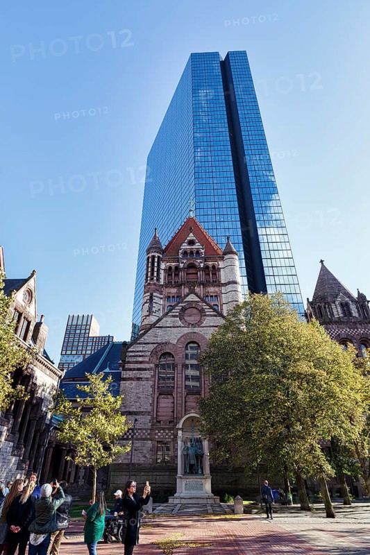 Tourist group photographs Trinity Church, glass façade of John Hancock Tower, various architectural styles at Copley Square, Back Bay, Boston, Massachusetts, New England, USA