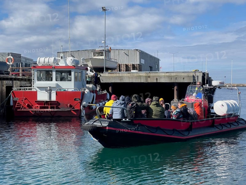 A group of tourists bird-watching on the incoming inflatable dinghy Speedboat, which drives tourists to Hornoy Vogel Island, Vardø, Finnmark, Norway