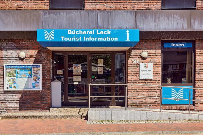Tourist information, library leak, public library, commercial building, brick building, entrance with door and ramp, stainless steel railing, shop window, showcase, sunny, main street, leak, district of North Frisia, Schleswig-Holstein, Germany