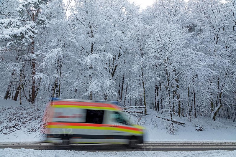 Ambulance driving through snowy landscape, trees, winter, snow, Sieversen, Samtgemeinde Rosengarten, Lower Saxony, Germany