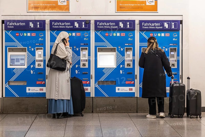 Ticket vending machine at Stuttgart Airport with travelers buying a public transport ticket. Stuttgart, Baden-Württemberg, Germany