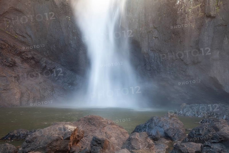 Daytime view from below of Wallaman Falls cascading into a rainforest gorge, Queensland, Australia