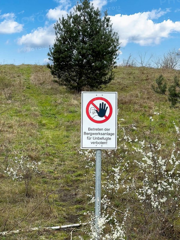 Warning sign prohibited from entering the mine complex for unauthorised persons! In front of a green mine heap Schöttelheide mining waste dump designated as a nature reserve since April 2025, Kirchhellen, Bottrop, North Rhine-Westphalia