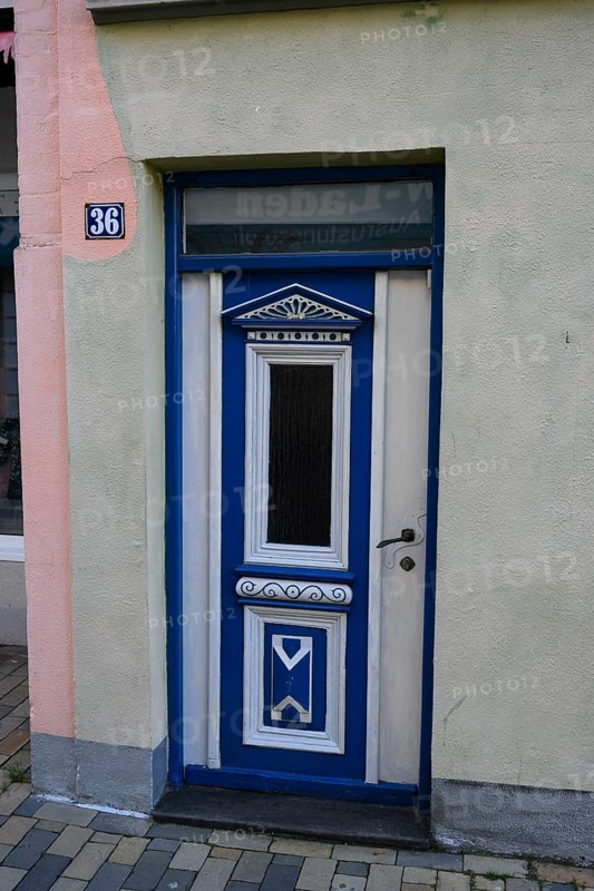 Historically decorated blue door as entrance to a building, a decorative blue wooden door with house number 36, Husum, Schleswig-Holstein, Germany