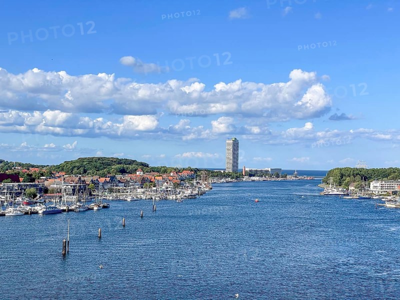 View over the Trave towards the mouth in the underground, the church of Travemünde and the Atlantic Hotel, with clouds and birds, Travemünde, Lübeck, Schleswig-Holstein, Germany