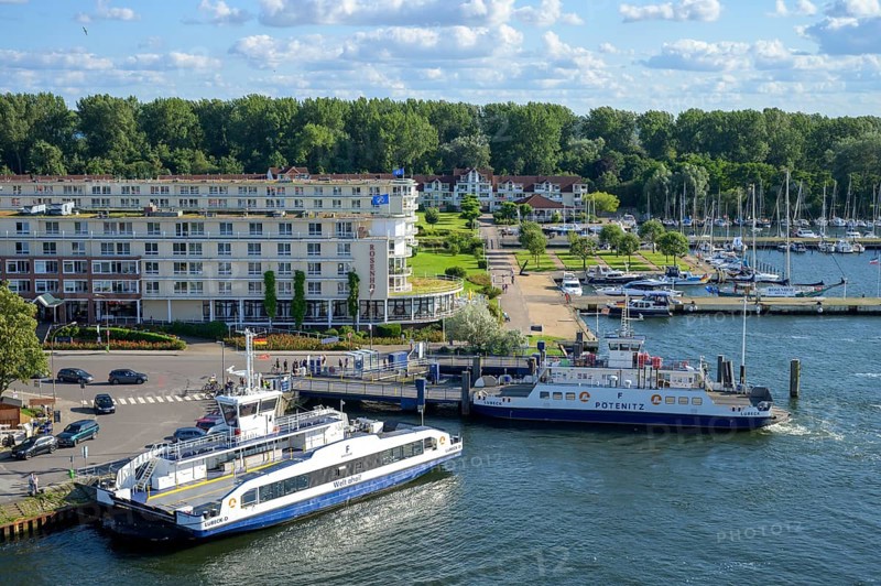 Ferries across the river Trave to Priwall in a busy small port in the town of Travemünde with surrounding buildings and yachts, Travemünde, Lübeck, Schleswig-Holstein, Germany