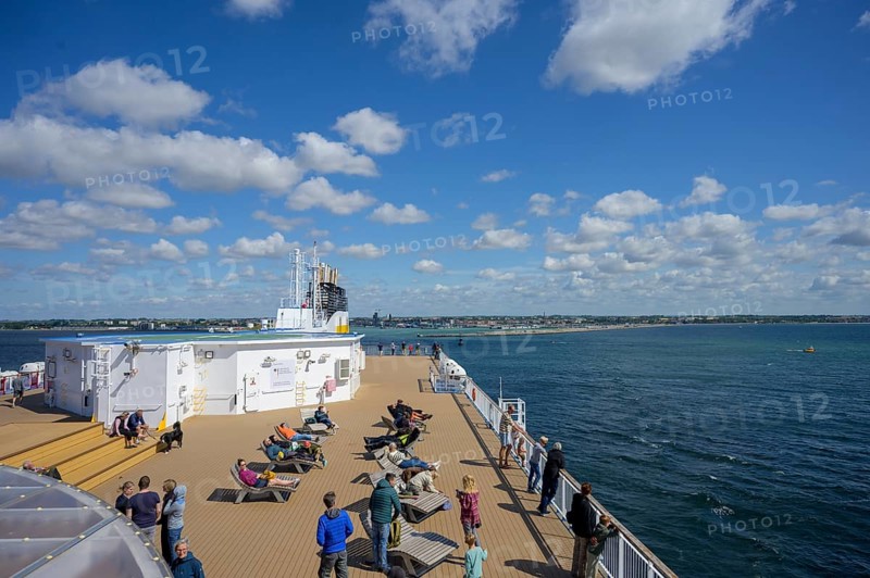 People relax on a TT-Line ship deck with a view of the sea under a blue sky, Trelleborg, Skåne län, Sweden