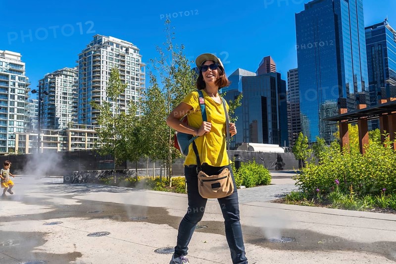Female tourist exploring the vibrant east village neighborhood in calgary, enjoying the cityscape and summer weather during her urban adventure