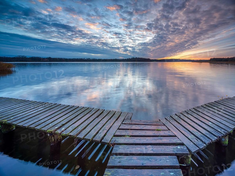 Evening at Schaalsee, wooden walkway with beautiful clouds in the sky at sunset, Schaalsee Biosphere Reserve, Mecklenburg-Western Pomerania, Germany