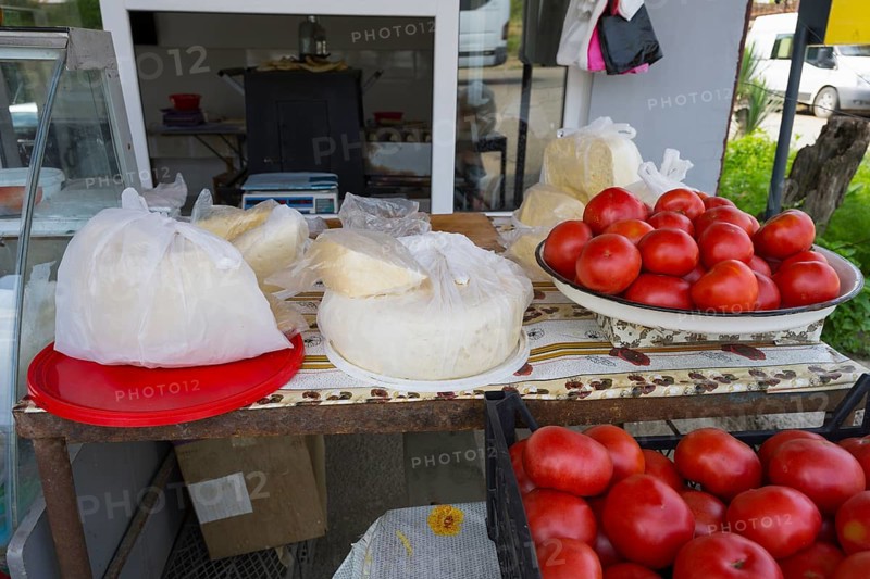 A market stall with tomatoes and cheese, fresh and on plates and wrapped in plastic, selling cheese and tomatoes, Badiauri, Kakheti region, Georgia